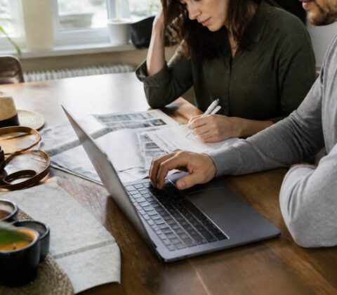 Vakantie vergelijken met checklist op tafel en laptop, zonder tekst op beeld