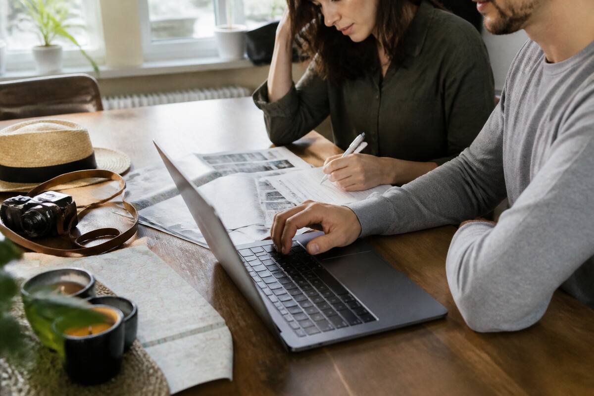 Vakantie vergelijken met checklist op tafel en laptop, zonder tekst op beeld
